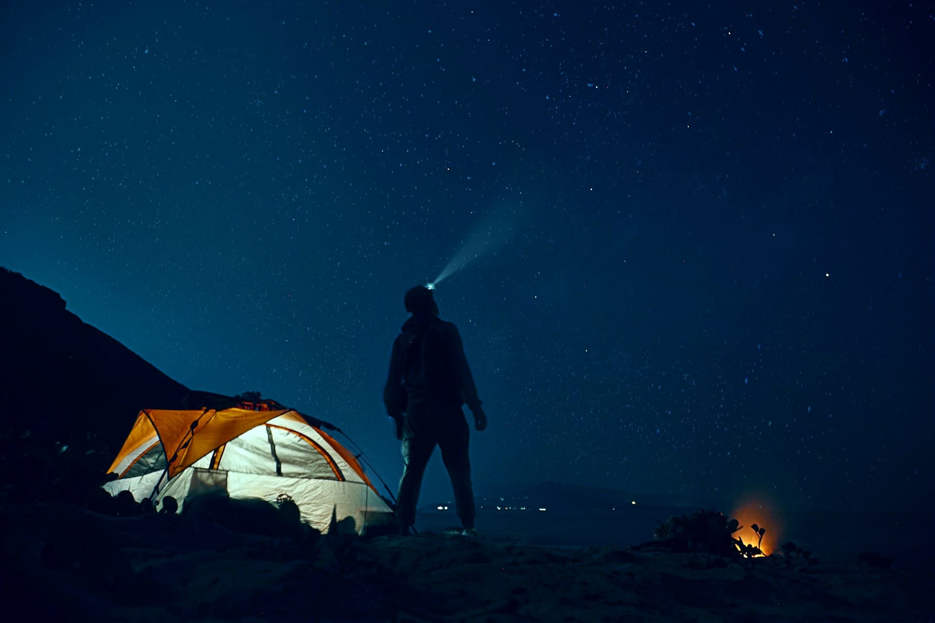 Tienda de campaña iluminada bajo un cielo estrellado